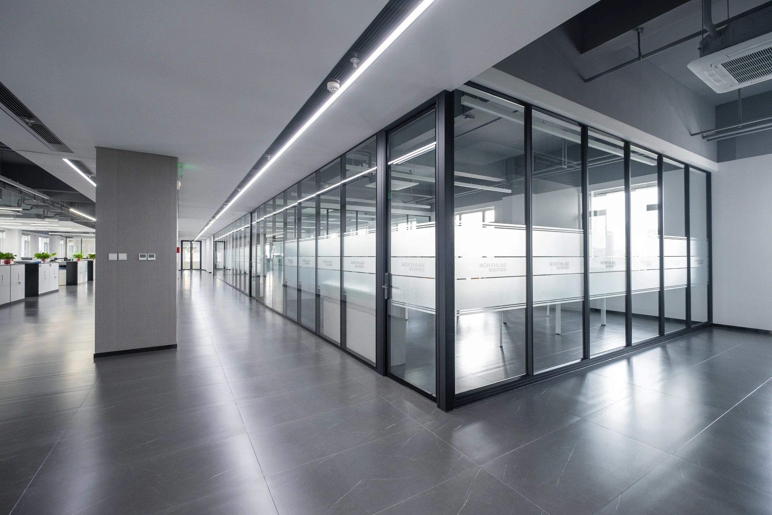 LEED glass partition with double glazing along an office corridor for higher acoustic separation