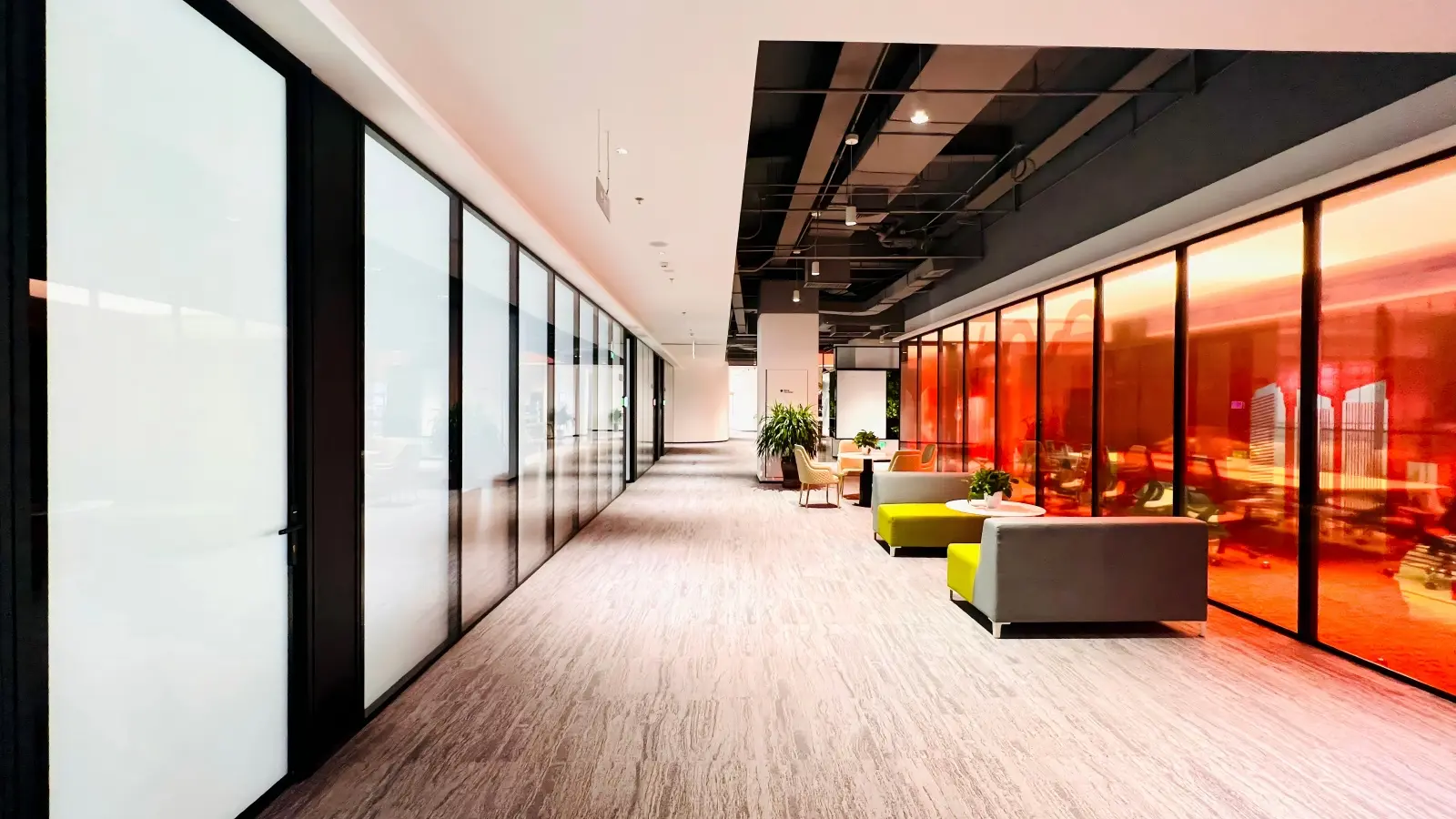 Everest hidden frame double glazed glass partition with red tinted glass and frosted privacy options in office corridor
