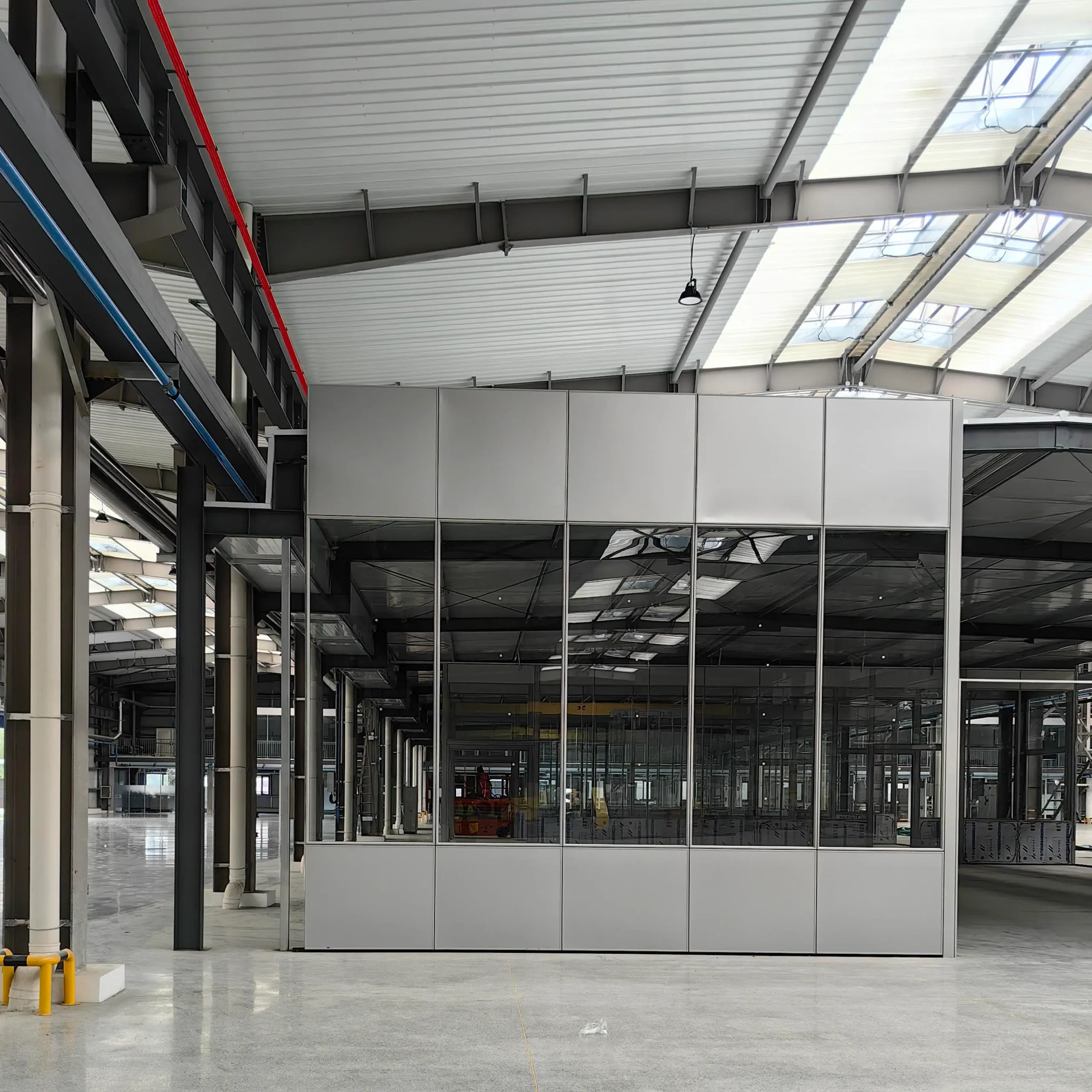 Fire partition vs fire barrier glazing limits — banded partition assembly with solid panels above and below a continuous glazed strip in an industrial building