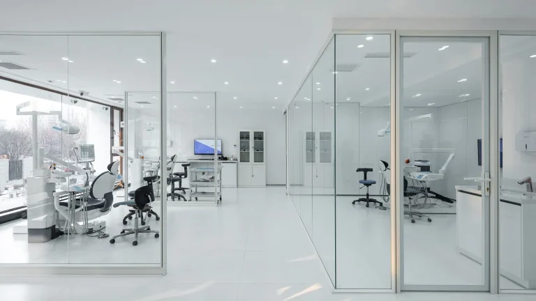 Frameless glass partition system creating multiple dental treatment rooms in clinic center (Dental Clinic project)