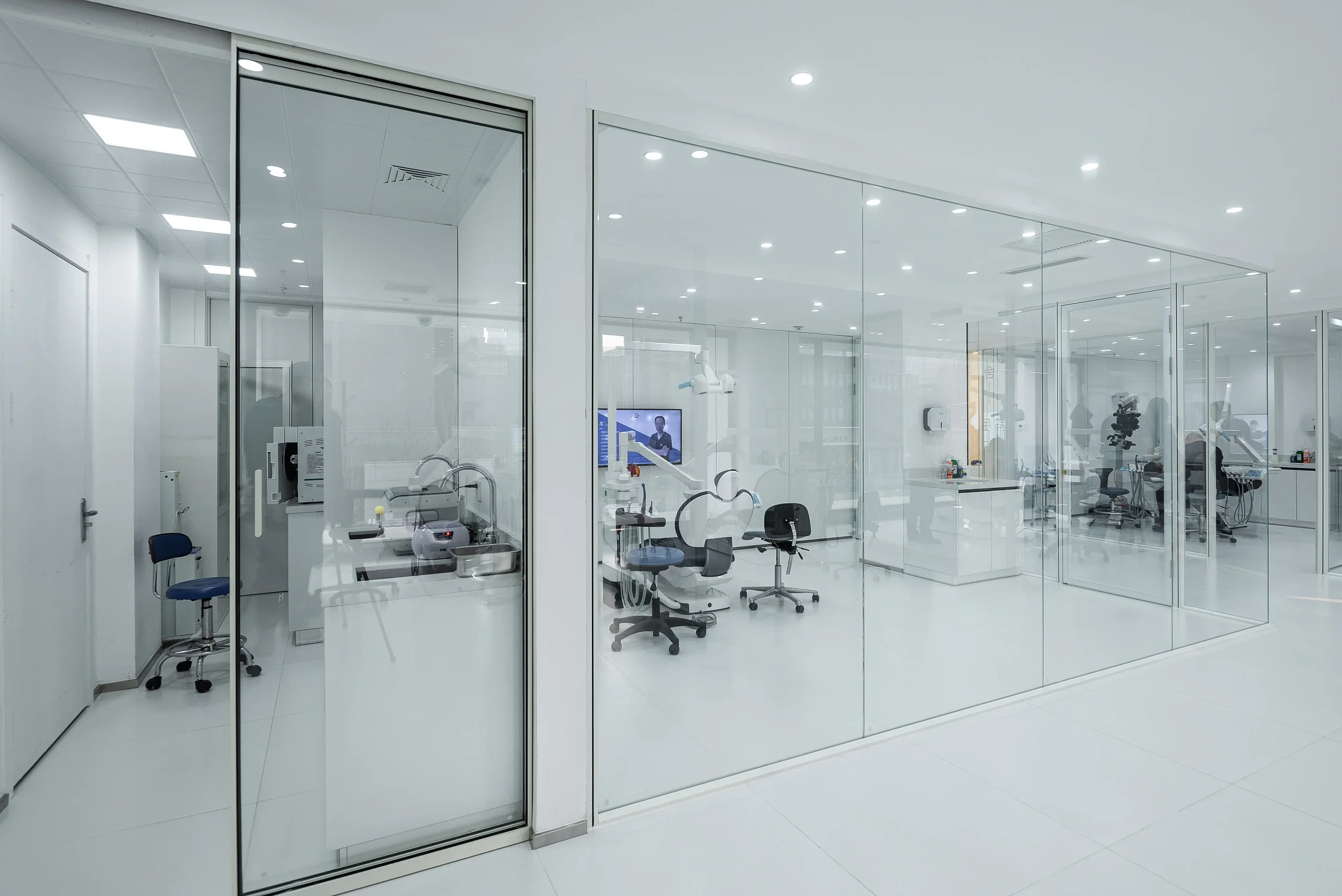 Dental clinic partition run along a treatment corridor, giving line of sight into each operatory from a single standing position