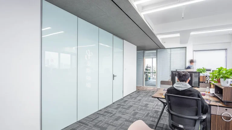 Painted-glass office wall beside glazed doors used in a painted glass vs solid partition comparison