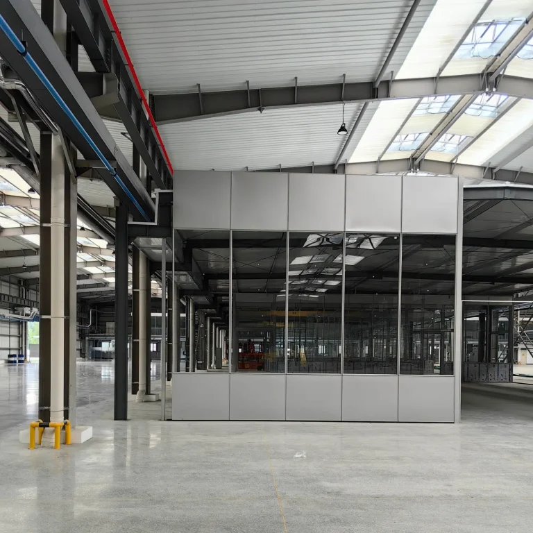 Solid panel partition wall installation in industrial factory environment with structural steel ceiling and concrete flooring