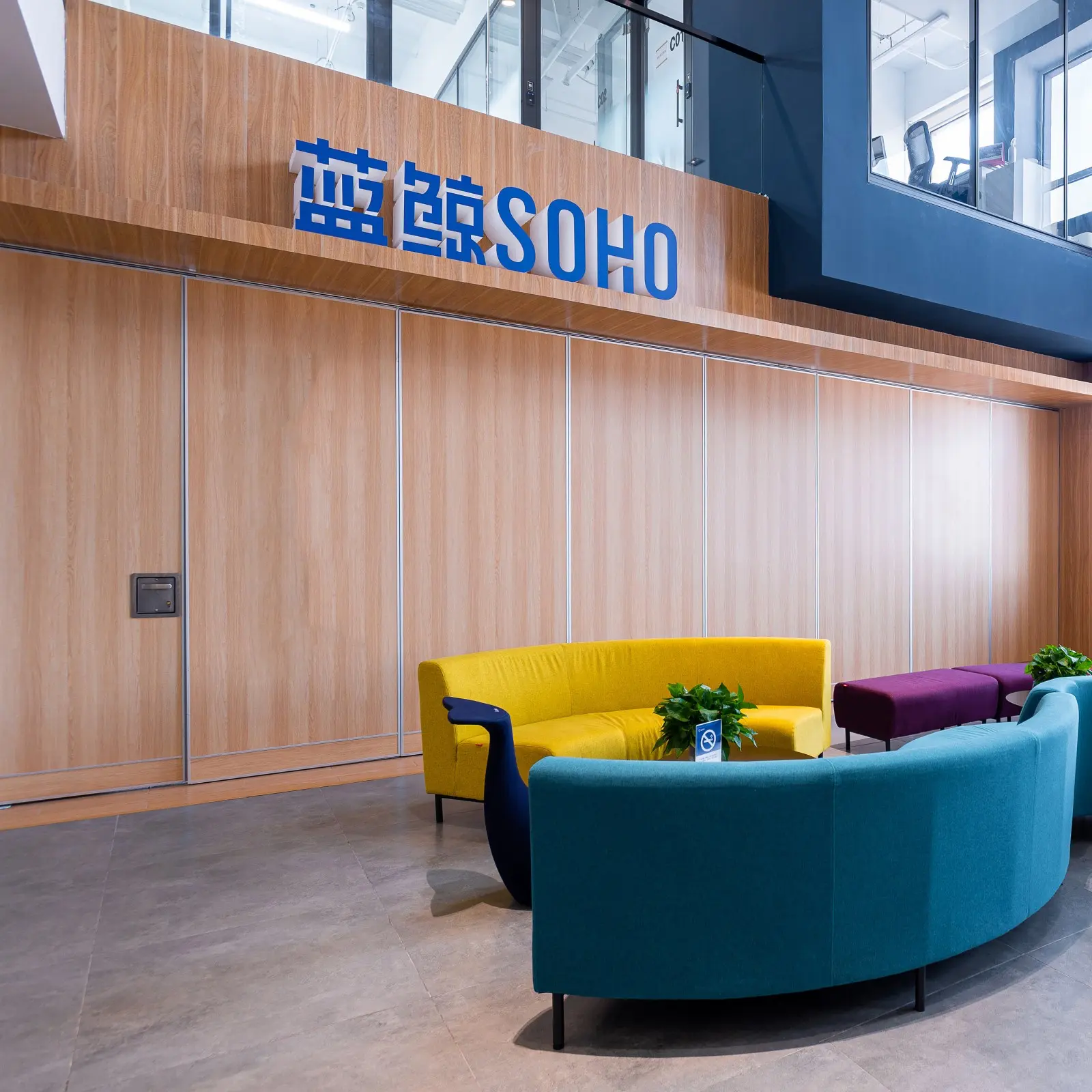 Paint glass partition application in reception lounge area — brand feature wall configuration for commercial office
