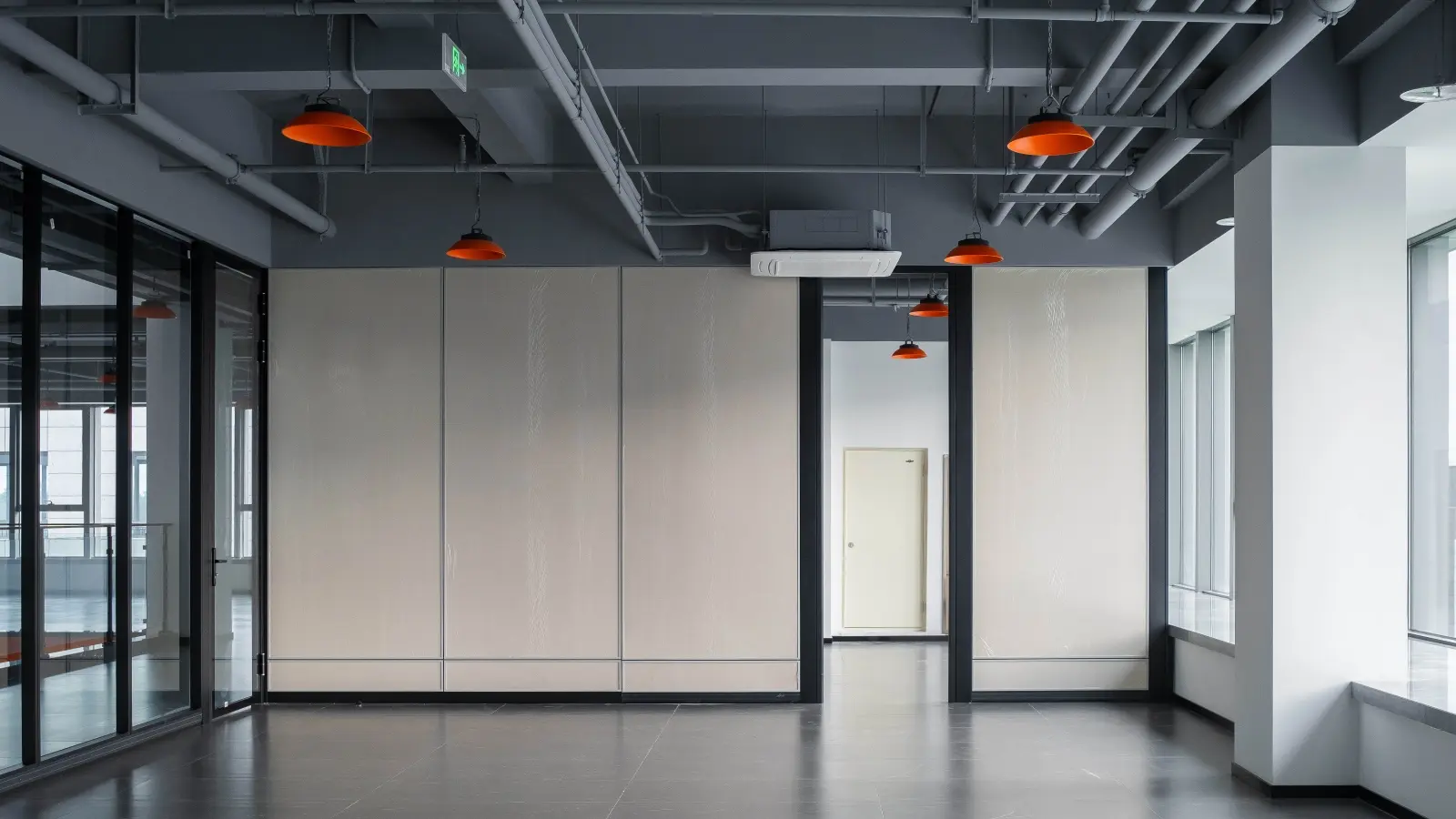 Modular solid partition wall system with beige panel infill and slim black aluminum framing in modern office reception