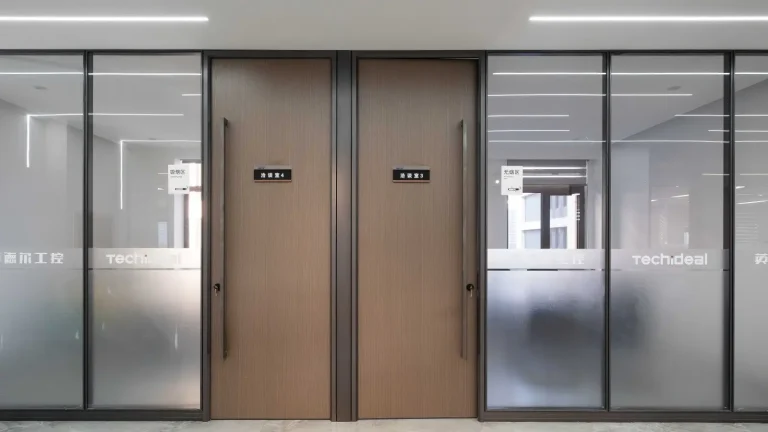 Wooden office door pair with dark wood finish for meeting rooms 3 and 4, flanked by techideal branded frosted glass partitions